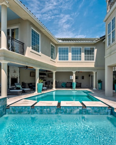 Luxury home with two swimming pools, covered patio with lounge chairs, and multi-level balconies
